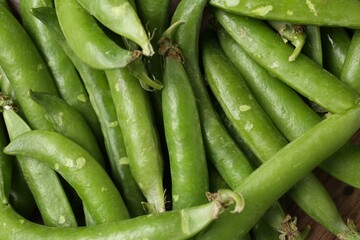 Fresh ripe green peas on wooden table, flat lay