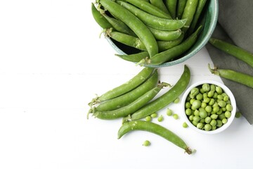 Fresh ripe green peas on white wooden table, flat lay. Space for text
