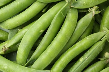 Fresh green pea pods as background, top view