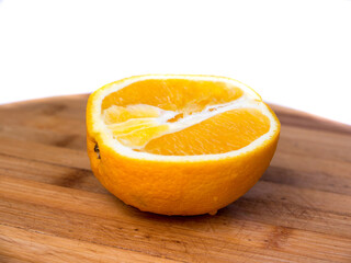 Half an orange on a wooden background.