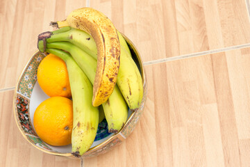 Bananas and oranges on a plate.
