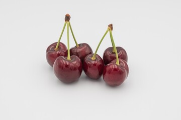 Fresh ripe dark red cherries with stalks, on white background