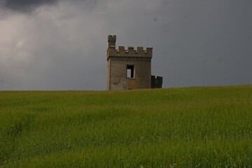 old defense tower in the green field at ardmore cliffwalk in ireland county waterford, irish coastline