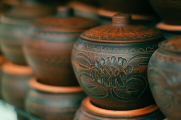 Intricate floral designs adorn handcrafted pottery, showcasing traditional craftsmanship.