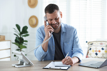 Naklejka premium Travel agent working at wooden table in office