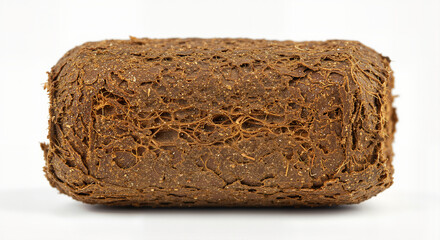 Compressed peat tablet with root structure on a white background 