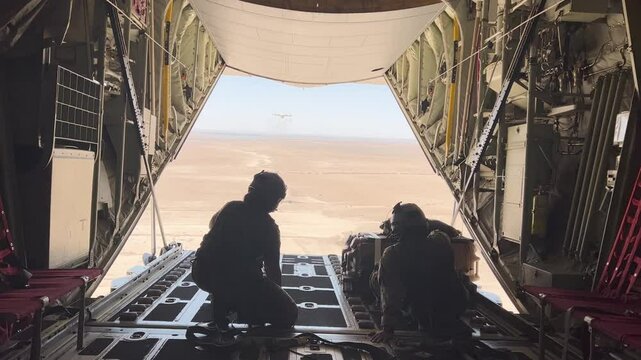 Military members pushing cargo in the back of a C-130 flying in Morocco