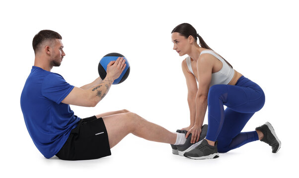 Coach training man with medicine ball on white background