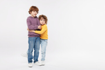 Cute little brothers hugging on white background