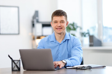 Man working on laptop at desk in office
