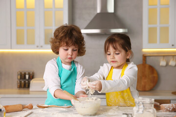 Cooking recipe. Cute children making dough for cookies at table in kitchen