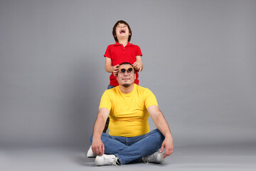 Father and his son on grey background