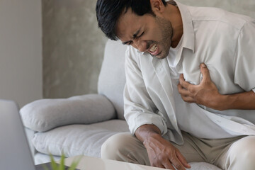 hand hold chest with heart attack symptoms,  man working hard have chest pain caused by heart...
