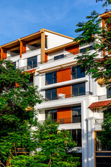 Modern residential building with trees and blue sky background