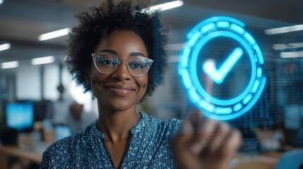 A confident woman with glasses smiles as she interacts with a glowing blue checkmark symbol in a modern office setting.