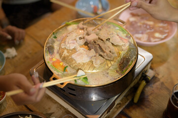 Close up of people eating Thai Food BBQ Grill Mu Kratha at night