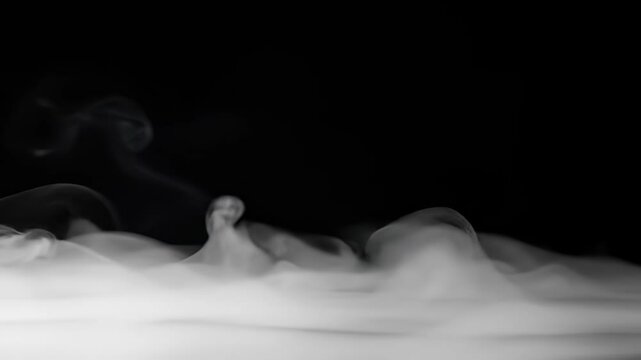 Dynamic white smoke abstractly drifts and swirls creating a mystical effect on a stark black background, highlighting its flowing texture and mysterious density with no people present.