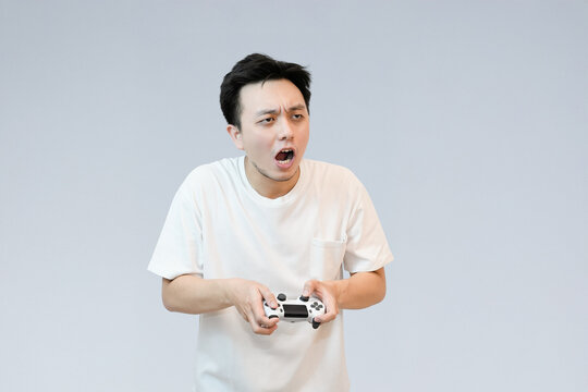 frustrated young asian man play and holding controller
