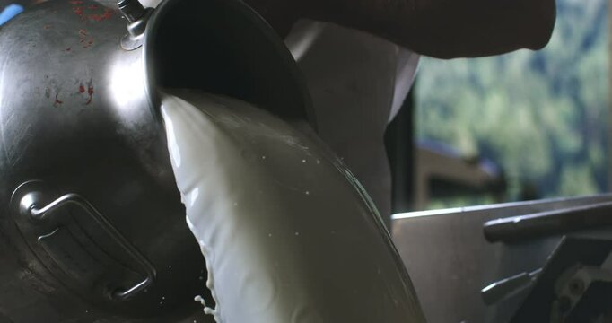 Cinematic Super slow motion macro of artisan cheesemaker is adding fresh bio eco milk during traditional cheese making process at cheese production creamery dairy factory at 1000 fps.