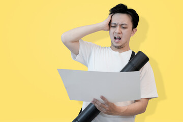 frustrated young asian man looking at the project sheet in isolated pink background