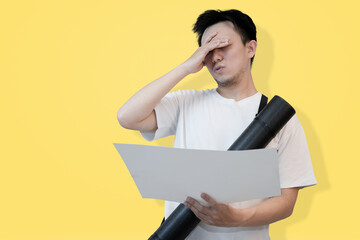 frustrated young asian man looking at the project sheet in isolated pink background
