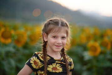Pretty young girl on the sunflowers field 