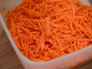 Fresh grated carrots in a plastic container