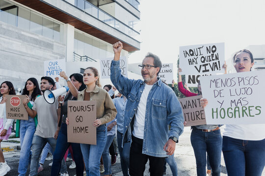 Group of Hispanic people activists protesting against high housing costs in Mexico City, women and men marching on streets for human rights and Housing crisis in Latin America