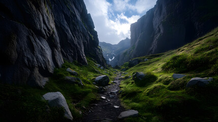 Obraz premium A summer trail that winds through rocky terrain, surrounded by towering cliffs and deep valleys in a mountain range.