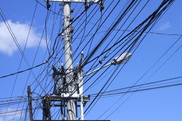 High voltage power lines on a bright sky blue background.