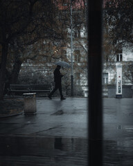 young man walking in the city with umbrella