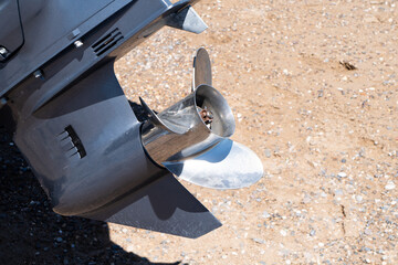 Outboard engine gearbox over sand background. Motor boat launch. Boat engine gear.