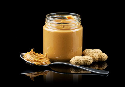  Peanut butter jar and tablespoon on on reflective black background
