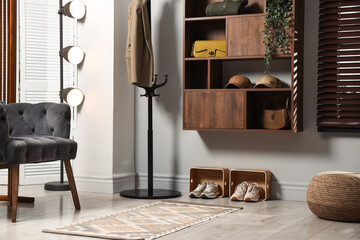 Shelving unit with different accessories and shoes in hallway