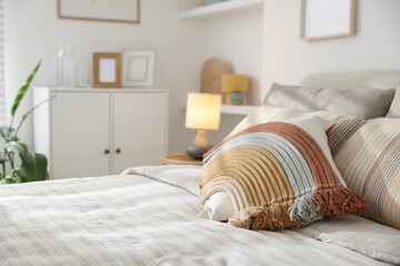 Comfortable bed with soft linens in room, closeup. Home textile