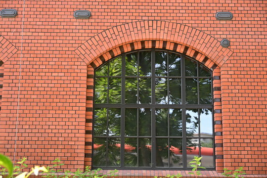 stare odrestaurowane okiennice odbicie drzewa refleks czerwona cegła