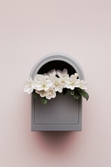 A gray mailbox with white flowers in the opening, against a light pink wall.