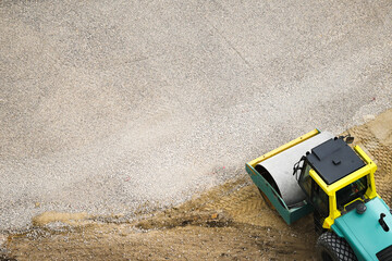 Heavy road vibratory roller compacts crushed stone at a construction site