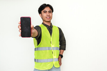 Happy Asian construction worker showing blank smartphone screen to the camera with cheerful...