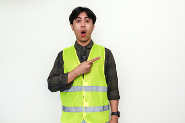 Portrait of a Asian construction worker man pointing sideways with a funny wow expression, isolated...