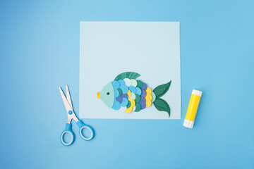 Flat lay paper fish craft scene with bubbles, scissors, and glue for toy brands, educational supply...