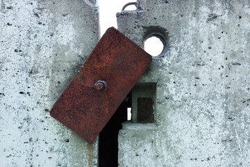 Two concrete slabs held together by a rusty metal bracket.