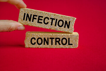 Infection Control symbol. Concept word Infection Control on brick blocks. Beautiful red background,...