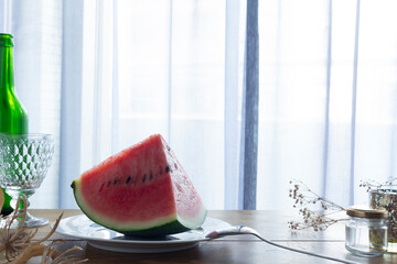 Soft natural light streams through pale blue curtains. A watermelon, the quintessential summer...