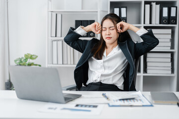 Stressed Asian Businesswoman with Headache Massaging Temples at Office Desk Tired Young...