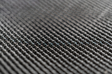 A close-up photo reveals the intricate diagonal pattern of carbon fiber, showcasing its strength...