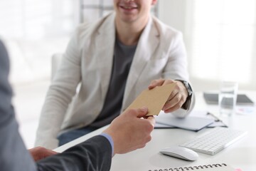 Money bonus. Employee receiving envelope from boss in office, closeup
