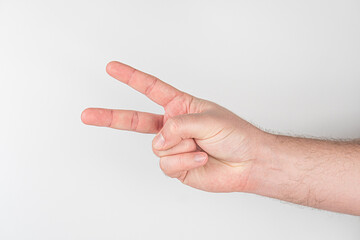 Close-up of a fair-skinned individuals arm, making a peace sign gesture Indoor, even lighting,...