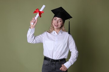 Happy student with diploma after graduation on green background