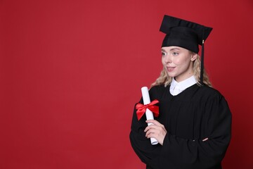 Happy student with diploma after graduation on red background. Space for text